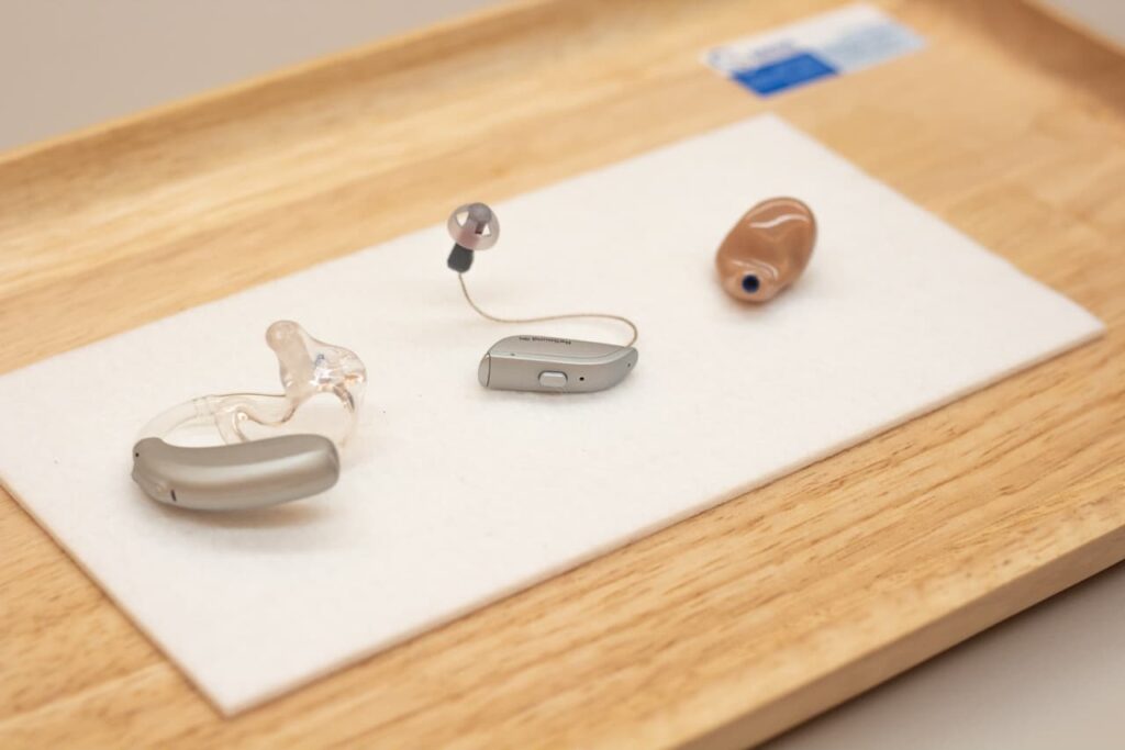 Auswahl verschiedener Hörgerätearten auf einem Tablett